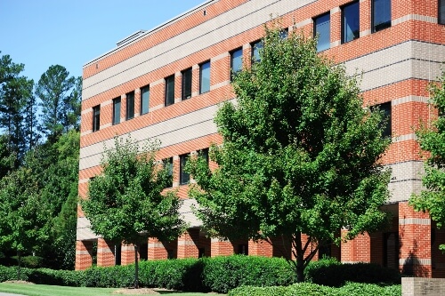 An industrial building with large trees on the side of it